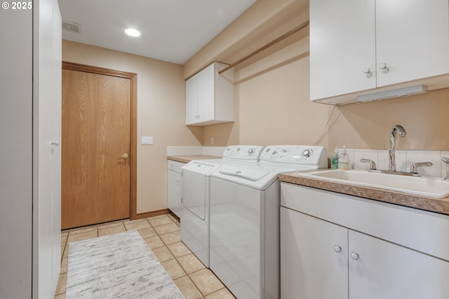 laundry area featuring light tile patterned floors, cabinet space, visible vents, a sink, and separate washer and dryer