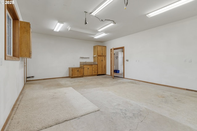 garage with baseboards and a sink