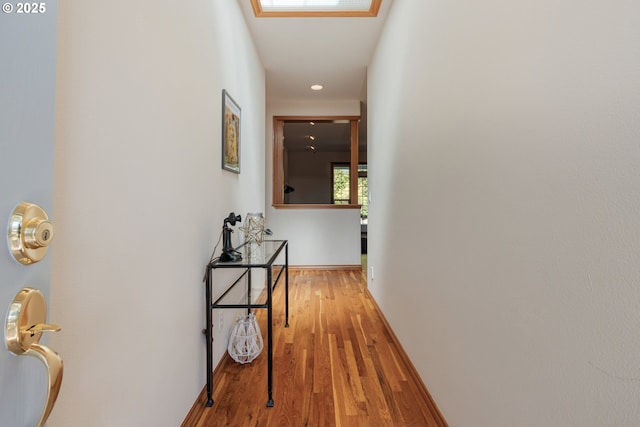 corridor featuring baseboards and wood finished floors