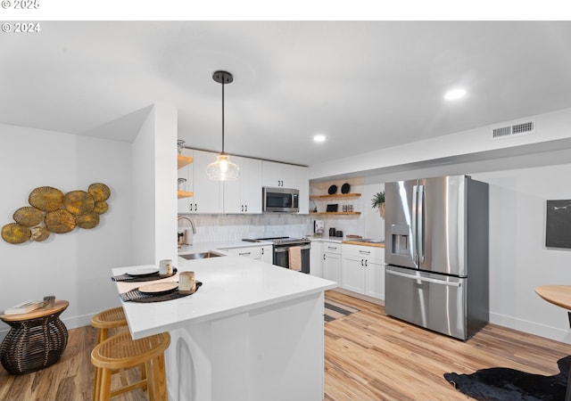 3707 SE Aldercrest Rd, Milwaukie, OR 97222 - kitchen with open shelves, stainless steel appliances, a sink, a peninsula, and white cabinets