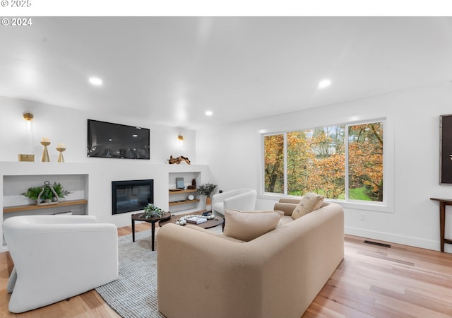 3707 SE Aldercrest Rd, Milwaukie, OR 97222 - living room featuring light wood finished floors, recessed lighting, a glass covered fireplace, and baseboards