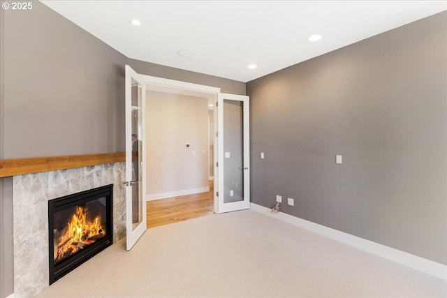 32092 SW Willamette Way E, Wilsonville, OR 97070 - unfurnished living room with a premium fireplace, carpet floors, french doors, recessed lighting, and baseboards