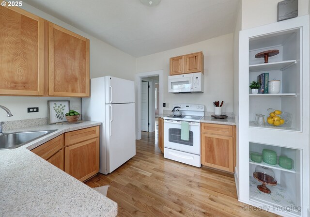 kitchen with white appliances, light hardwood / wood-style floors, and sink