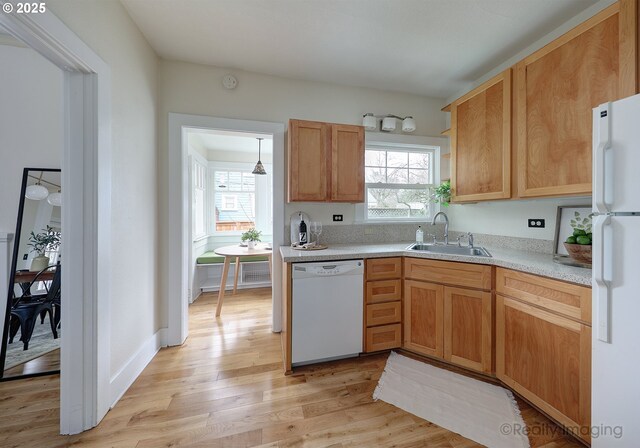 kitchen featuring sink, white appliances, and light wood-type flooring