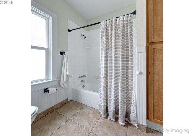 bathroom with toilet, tile patterned floors, a healthy amount of sunlight, and shower / bath combo with shower curtain