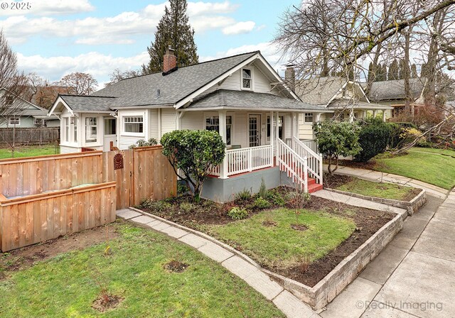 bungalow featuring covered porch and a front yard