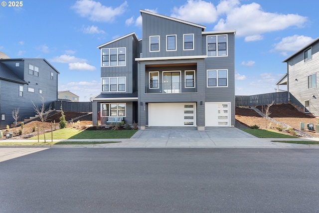 contemporary house featuring an attached garage, driveway, fence, and board and batten siding