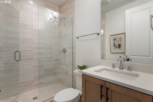 bathroom featuring toilet, a stall shower, vanity, and visible vents