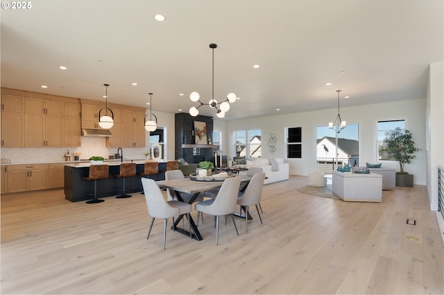 dining room with a chandelier, light wood-type flooring, and recessed lighting