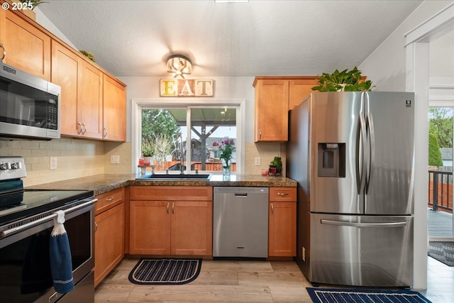 901 SE Olympia Dr, Vancouver, WA 98683 - kitchen with light wood finished floors, a sink, tile counters, backsplash, and appliances with stainless steel finishes