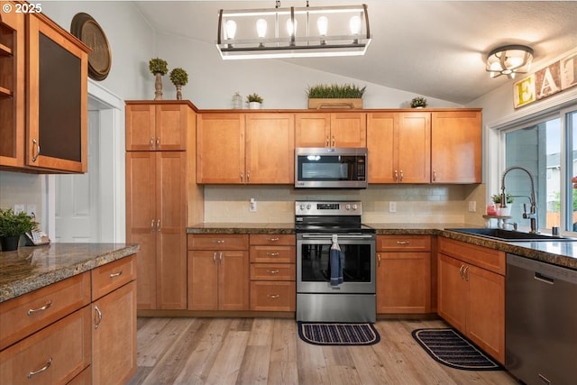 901 SE Olympia Dr, Vancouver, WA 98683 - kitchen with a sink, lofted ceiling, stainless steel appliances, brown cabinetry, and backsplash