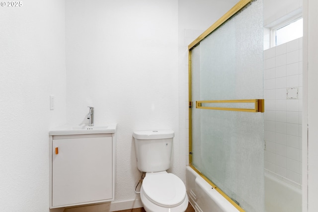 full bathroom featuring vanity, bath / shower combo with glass door, and toilet