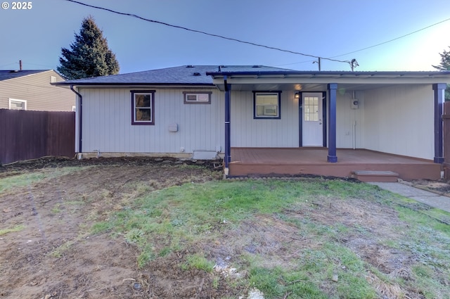 back of property featuring a porch and a lawn