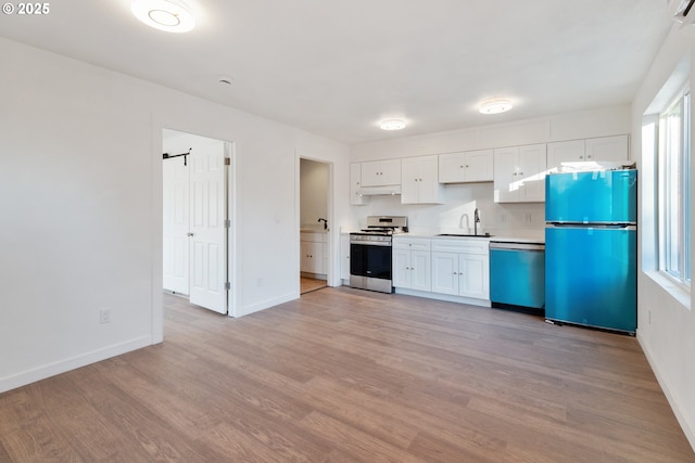 kitchen with stainless steel appliances, light hardwood / wood-style floors, sink, and white cabinets