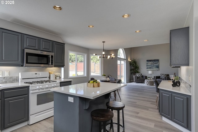 9711 SE Top O Scott St, Happy Valley, OR 97086 - kitchen with stainless steel microwave, white gas range oven, open floor plan, light countertops, and recessed lighting