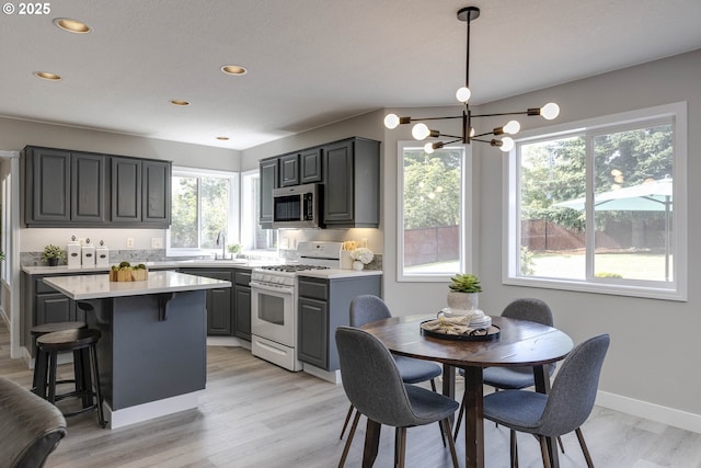 9711 SE Top O Scott St, Happy Valley, OR 97086 - kitchen with white gas stove, plenty of natural light, stainless steel microwave, light countertops, and recessed lighting