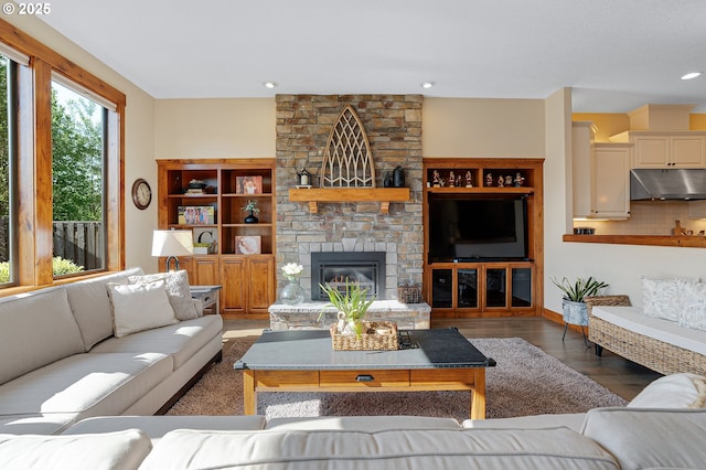 living room with recessed lighting, wood finished floors, and a fireplace