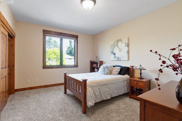 bedroom with light colored carpet and baseboards