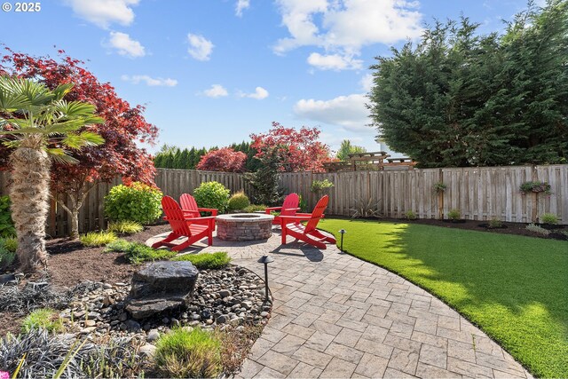 view of patio featuring a fenced backyard and an outdoor fire pit
