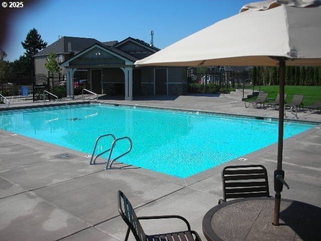 pool with fence and a patio area