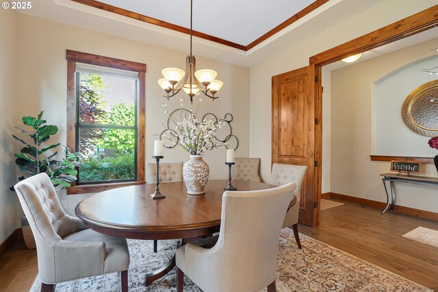 dining room with baseboards, wood finished floors, and a notable chandelier