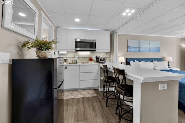 kitchen featuring appliances with stainless steel finishes, dark wood-style flooring, light countertops, recessed lighting, and backsplash