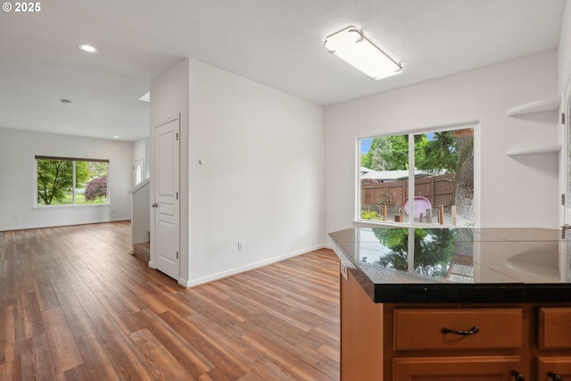 kitchen featuring light wood-style flooring, open floor plan, baseboards, open shelves, and recessed lighting