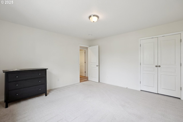 unfurnished bedroom with carpet, a closet, and baseboards