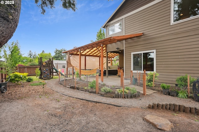 view of yard featuring a playground, fence, and a patio area