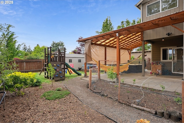 view of yard featuring fence, a playground, and a patio