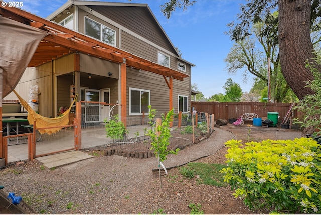 rear view of house with fence and a patio area