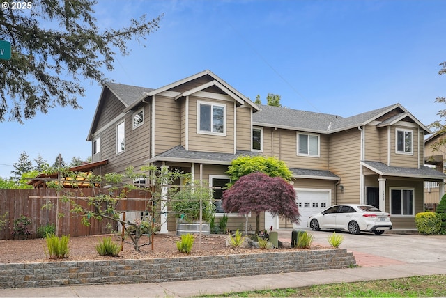 view of front facade with fence, an attached garage, concrete driveway, and roof with shingles