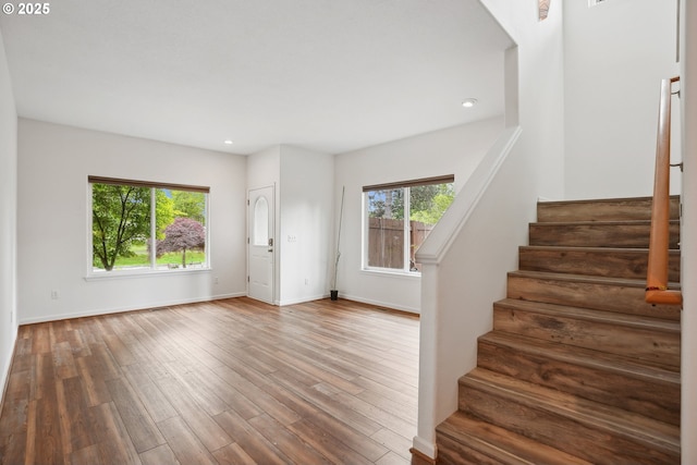 entrance foyer featuring healthy amount of natural light, stairway, baseboards, wood finished floors, and recessed lighting