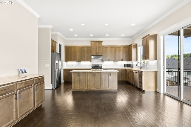 16944 SW Birdsong St, Beaverton, OR 97007 - kitchen with appliances with stainless steel finishes, a sink, a kitchen island, backsplash, and crown molding