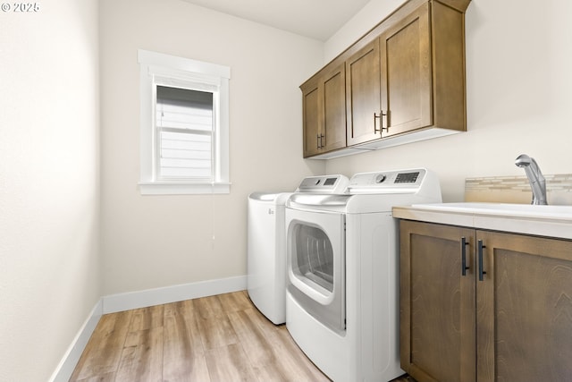 16944 SW Birdsong St, Beaverton, OR 97007 - washroom featuring cabinet space, washing machine and clothes dryer, light wood-style flooring, and baseboards