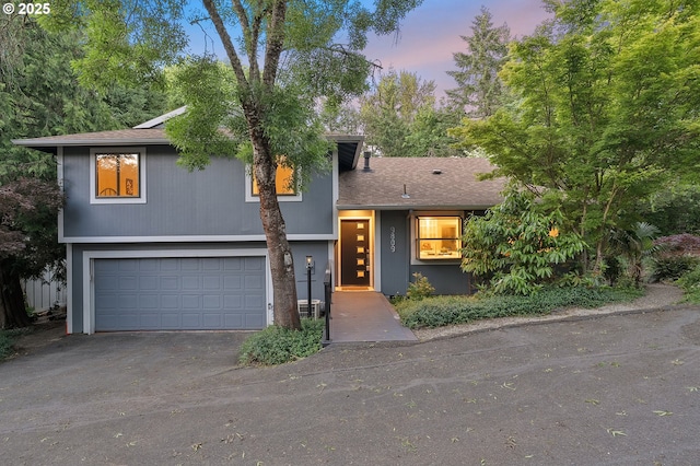 9809 SW Quail Post Rd, Portland, OR 97219 - tri-level home with an attached garage, asphalt driveway, and a shingled roof