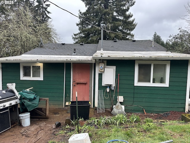 rear view of house featuring roof with shingles