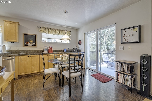 dining space featuring dark wood-style floors and a textured ceiling