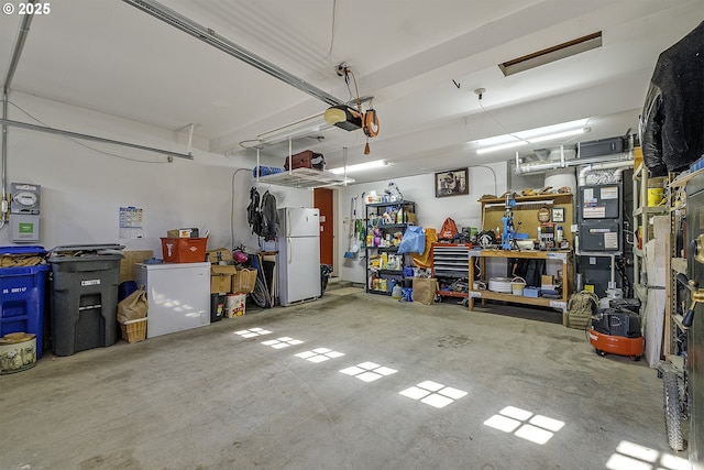 garage with a garage door opener, freestanding refrigerator, and a workshop area