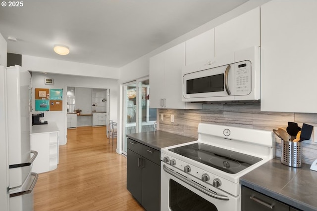 530 N Hayden Bay Dr, Portland, OR 97217 - kitchen with white appliances, light wood-style floors, tasteful backsplash, white cabinetry, and dark cabinets