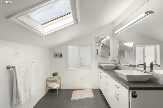 530 N Hayden Bay Dr, Portland, OR 97217 - full bath featuring vaulted ceiling, a skylight, double vanity, tile patterned flooring, and baseboards
