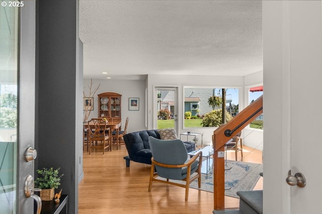 530 N Hayden Bay Dr, Portland, OR 97217 - living room featuring light wood finished floors, a textured ceiling, and stairs