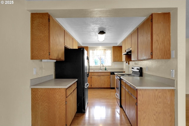 945 Irving Ct, Eugene, OR 97404 - kitchen featuring stainless steel range with electric stovetop, under cabinet range hood, freestanding refrigerator, light wood finished floors, and a textured ceiling