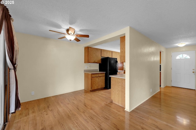 945 Irving Ct, Eugene, OR 97404 - kitchen with freestanding refrigerator, a textured ceiling, light countertops, ceiling fan, and light wood finished floors