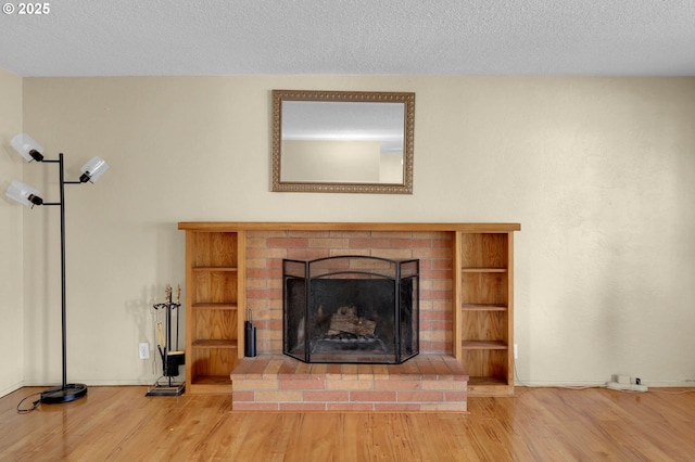 945 Irving Ct, Eugene, OR 97404 - detailed view of wood finished floors, a fireplace, and a textured ceiling