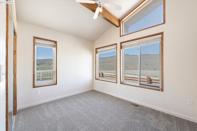 empty room featuring baseboards, ceiling fan, high vaulted ceiling, beam ceiling, and carpet floors