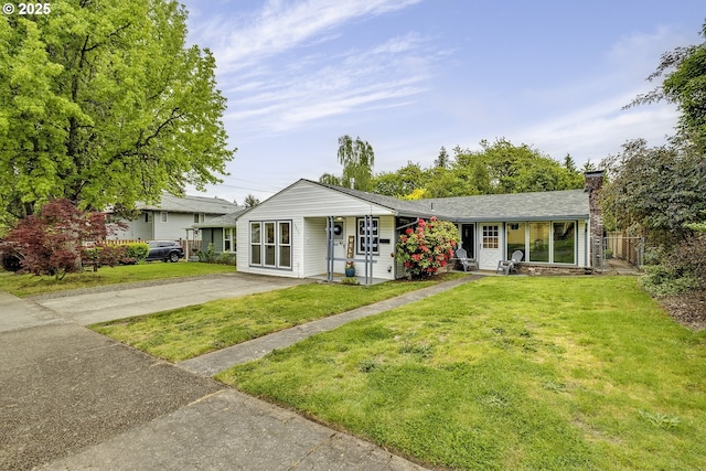 view of front of house featuring a chimney and asphalt driveway