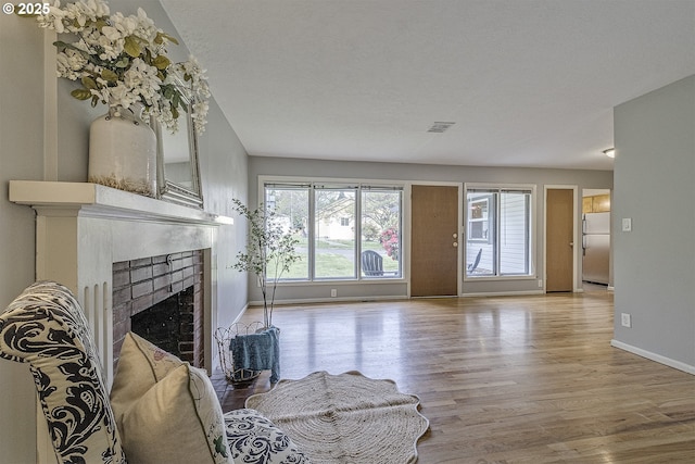 living area with wood finished floors, baseboards, and a fireplace