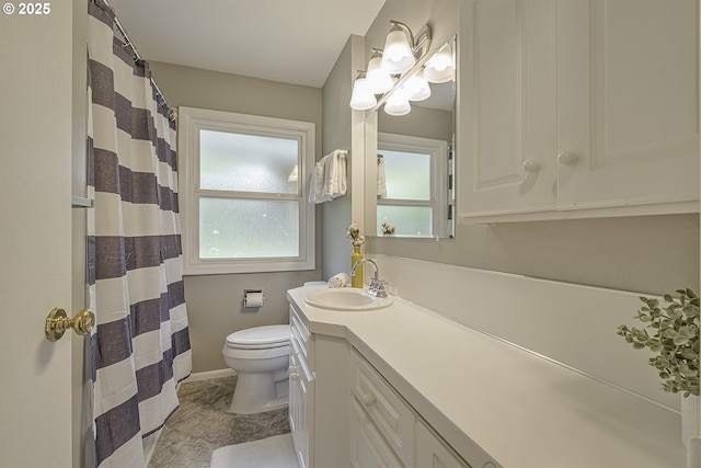full bathroom with toilet, vanity, marble look tile flooring, and plenty of natural light