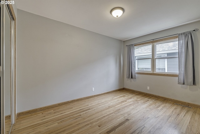 unfurnished room featuring light wood-style floors and baseboards